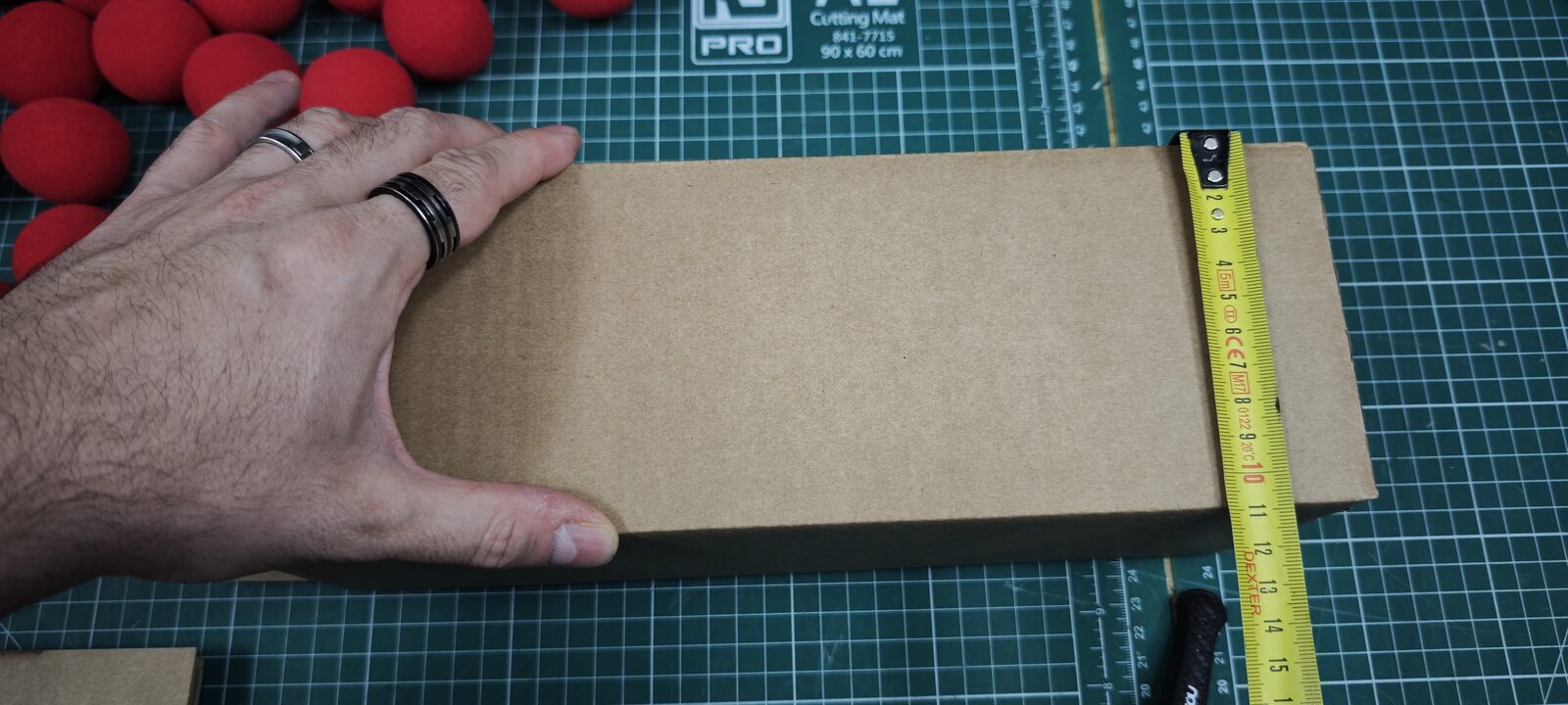 Mesure d'un côté du carton au mètre ruban : environ 11 cm