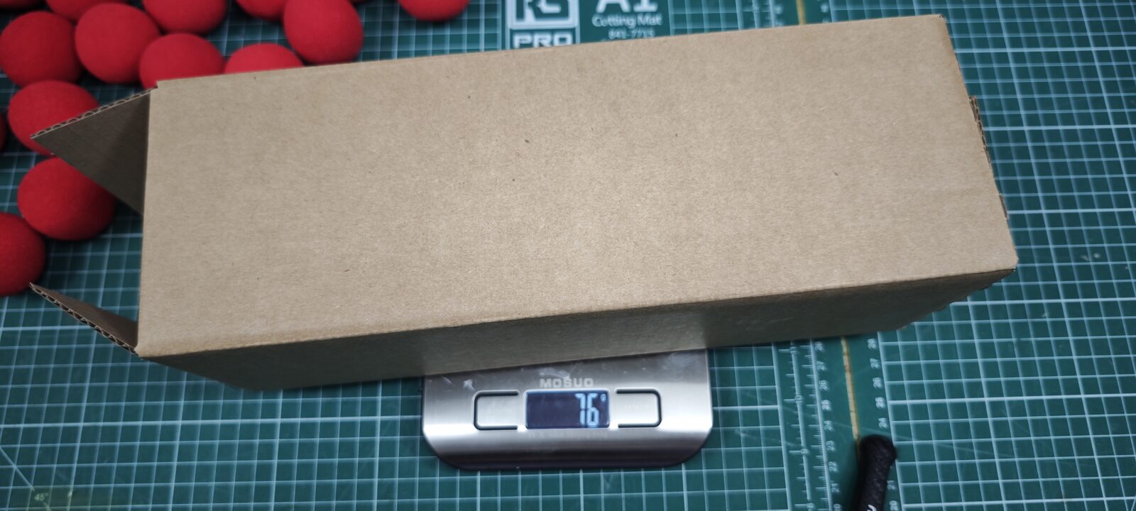 Le carton posé sur une balance, 76 g