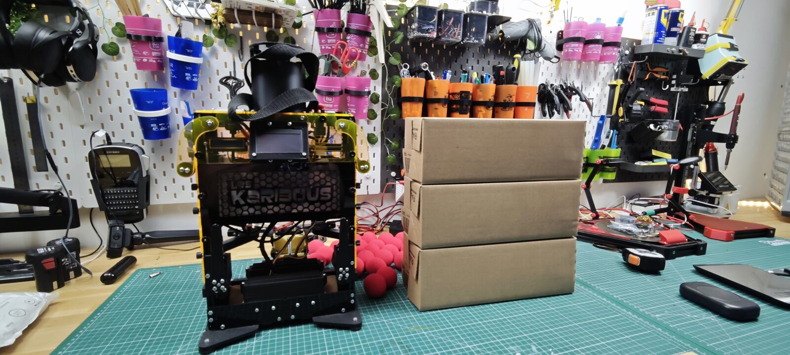 Trois cartons empilés à côté du robot de l'année dernière, vue de face