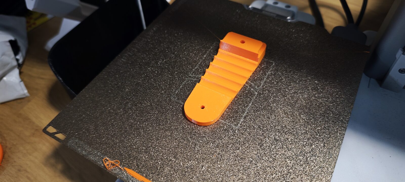 Le doigt en TPU orange sur le plateau de l'imprimante