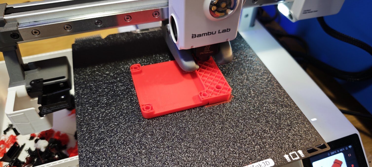 Le support rouge en cours d'impression sur la Bambu Lab, plateau texturé